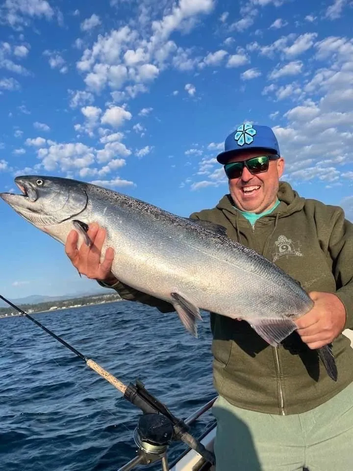 Friends holding Coho salmon on Campbell River fishing charter